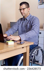 Young man in wheelchair at work 