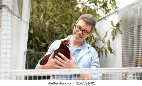 Young Man In White Coat Hold Chicken In Hand And Talk At Hen House. Farmers Inspect And Record The Quality Data Of The Chicken, Veterinarian Is Checking Poultry Health In Farm, Farmer Production.