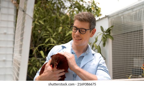 Young Man In White Coat Hold Chicken In Hand And Talk At Hen House. Farmers Inspect And Record The Quality Data Of The Chicken, Veterinarian Is Checking Poultry Health In Farm, Farmer Production.