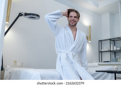 A young man in a white robe in a spa salon