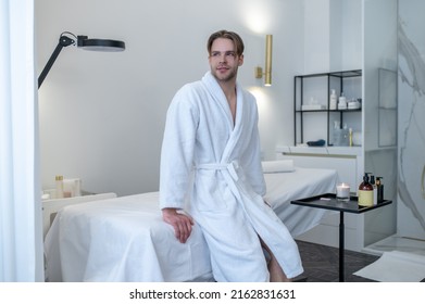 A young man in a white robe in a spa salon