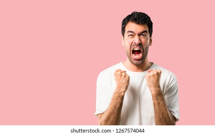 Young man with white shirt annoyed angry in furious gesture. Frustrated by a bad situation on isolated pink background - Shutterstock ID 1267574044