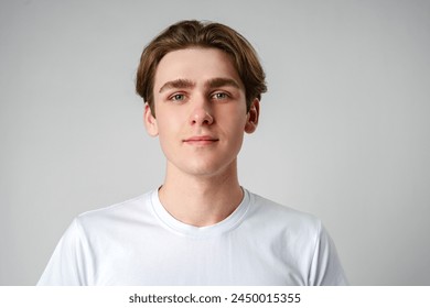 Young Man in White Shirt Looking at Camera - Powered by Shutterstock