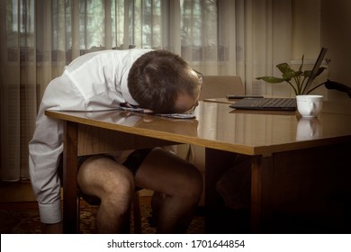 Young man in a white shirt with a tie and underwear was working at a computer at home tired and laid his head on the table. Tinted.