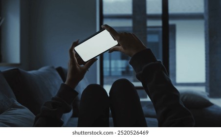 young man in white sweater sitting on bed using tablet in living room at home - Powered by Shutterstock