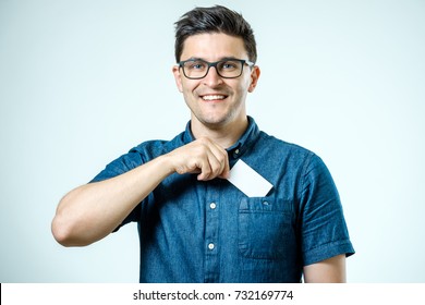 Young Man Who Takes Out Blank Business Card From Pocket Of Shirt. Isolated Background