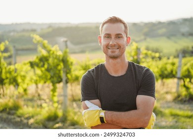 Young man wine producer man smiling in camera with vineyard in background - Organic farm and small business concept - Focus on his face - Powered by Shutterstock