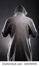 Young man in winter coat and hood rear view on back