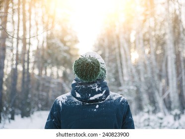 Young Man In A Winter Outfit Standing In The Middle Of A Winter Snowy Forest