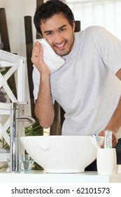 Young Man Wiping His Face In The Bathroom