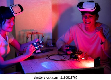 Young Man And Young Woman Amateur Inventor Testing Electronic Device Model Inventions All Wear Vr Glasses To Show High Technology In Black Light Mood.