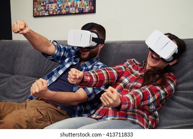 A young man and woman in casual clothes playing racing game using virtual reality headset - Powered by Shutterstock