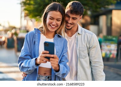 Young man and woman couple smiling confident using smartphone at street - Powered by Shutterstock