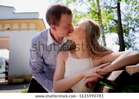 Young man and woman couple walk in the park. Spring or summer love story. Young happy family on the bench