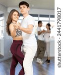 Young man and young woman dance ballroom dance waltz in studio