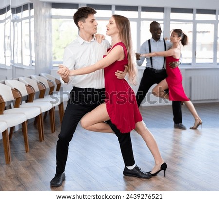 Young man and young woman dance couple tango dance in studio