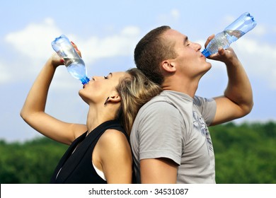 Young man and woman drinking water from a bottle