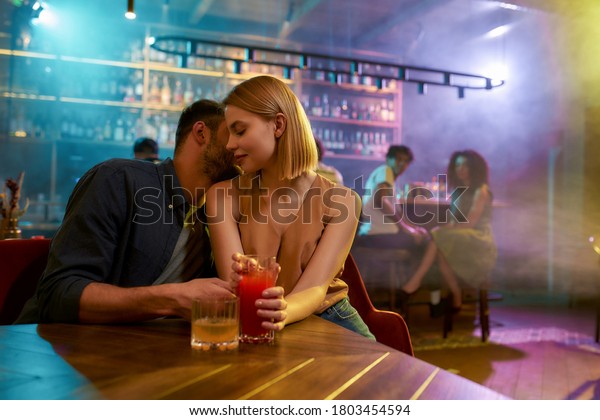 Young man and woman flirting in the bar,\
enjoying drinks and conversation. Love, couple, romance concept.\
Selective focus. Horizontal\
shot