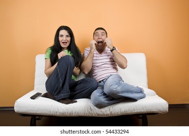 Young Man And Woman ,friends Watching TV  A Horror Movie And They Are Scared