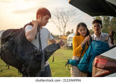 Young Man And Woman Helped To Lift Bag From The Car To Go To Picnic In The Summer Holidays.They Are Happy And Have Fun On Holidays.