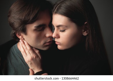 Young man and young woman are hugging on the black background