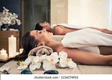 Young Man And Woman Lying Down On Massage Beds At Asian Luxury Spa And Wellness Center