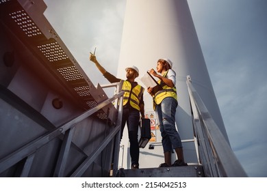 Young man and woman maintenance engineer team working in wind turbine farm. Generator station, renewable energy - Powered by Shutterstock