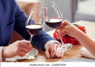 Young Man And Woman On Date In Restaurant Sitting Table Holding Glasses Drinking Red Wine Cheers Close-up