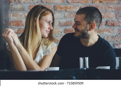 Young Man And Woman On A Date Flirting. Couple Sitting In The Coffee Shop