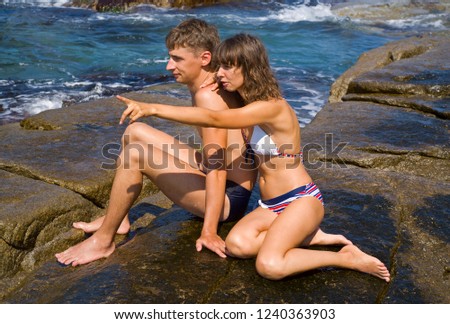 The young man and woman on reefs in sea.