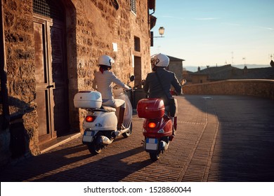 Young Man And Woman On Vespa Scooter. Bikers Couple.