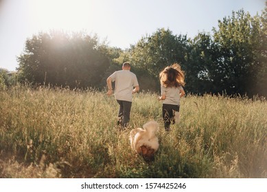 Young Man And Woman Running Away With Their Dog