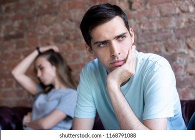Young man and woman sitting on different sides of each other and not talk. Unhappy couple, boyfriend and girlfriend fight. Problem difficulties, dissatisfaction, misunderstanding in relations concept