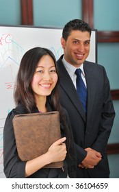 Young man and woman standing near whiteboard - Shutterstock ID 36104659