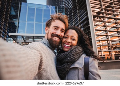 Young man and woman tourist making selfie and smile to the camera. Boyfriend and girlfriend having fun outdoors doing a portrait with smartphone. Travel concept. High quality photo - Powered by Shutterstock