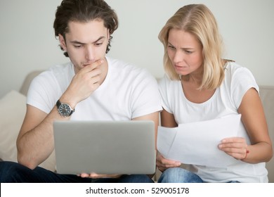 Young man and woman working with laptop, holding documents, using online mortgage calculator to save money on home loan, applying for visa, mother and son choosing educational program, checking test - Powered by Shutterstock