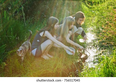 Young Man And Women Catching Tadpoles