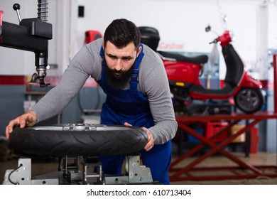 Young man worker working at restoring wheel in motorcycle workshop - Powered by Shutterstock