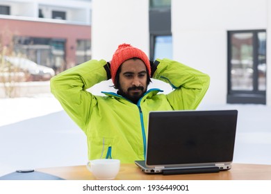 Young Man Working With Laptop Outside In Snow