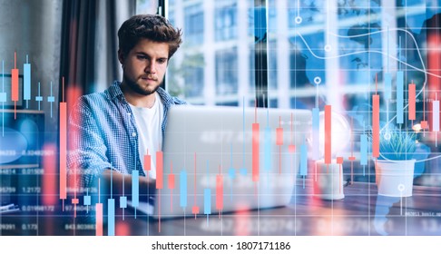 Young man working at modern office.Technical price graph and indicator, red and green candlestick chart and stock trading computer screen background. Double exposure. Trader analyzing data