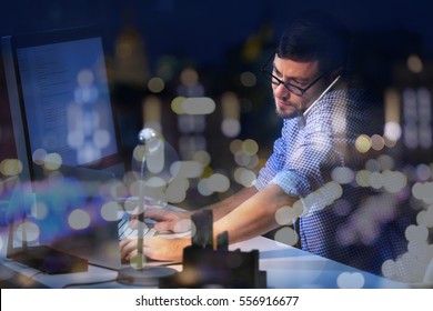 Young Man Working At Office And Night Cityscape Reflection On Window