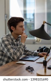 Young man working on computer in office interior