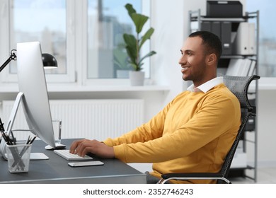 Young man working on computer at table in office