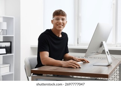 Young man working on computer at table in office