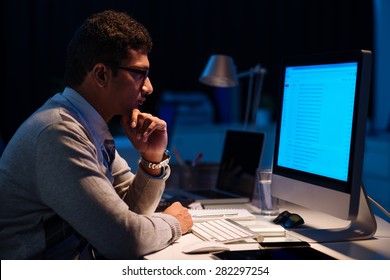 Young Man Working On Computer At Night In Dark Office