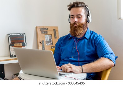 Young Man working on a Computer and listening to Music