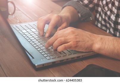 Young man working on computer. StartUp. working digital tablet dock keyboard and laptop with smart phone and compact server on wooden desk. Freelance concept. successful programmer. Blurred background