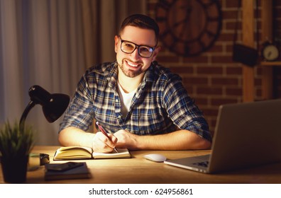 Young Man Working On The Computer At Home At Night In The Dark 
