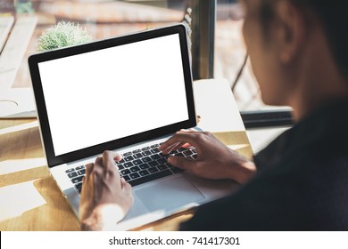 Young man working on his laptop with blank copy space screen for your advertising text message in office, Back view of business man hands busy using laptop at office desk