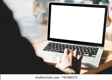 junger Mann, der an seinem Laptop arbeitet, mit leerem Bildschirm für den Werbetext im Büro, Rücksicht auf Geschäftsleute, die mit Laptop am Büroschreibtisch beschäftigt sind